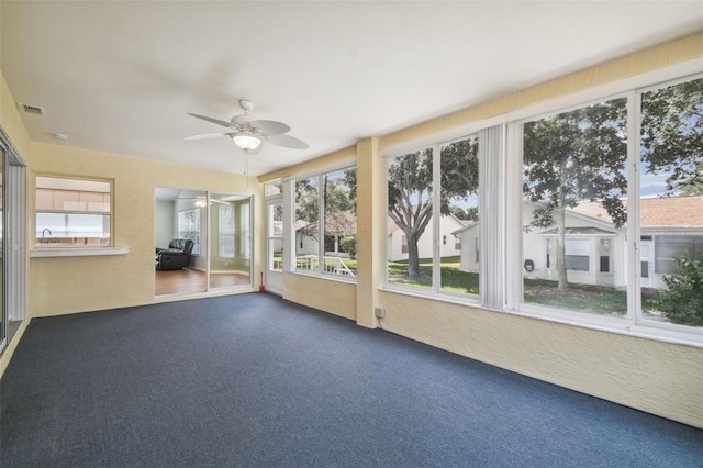 unfurnished sunroom featuring ceiling fan