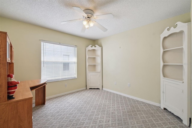 unfurnished office with light carpet, a textured ceiling, and ceiling fan