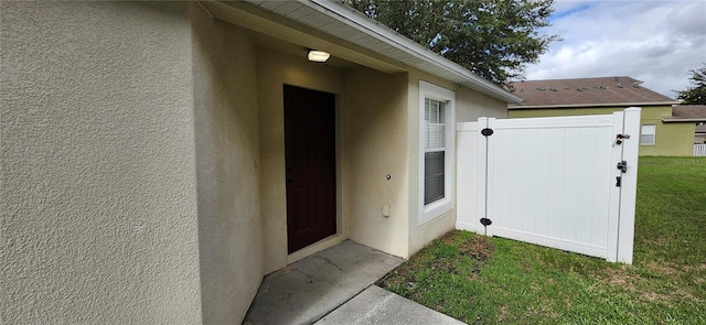 doorway to property featuring a lawn