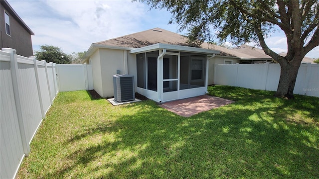 back of house with a lawn, central AC, and a sunroom