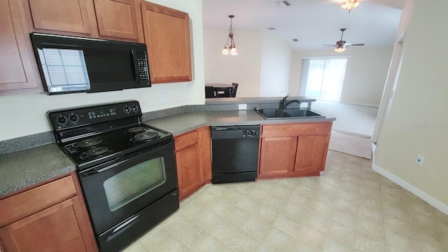 kitchen with a peninsula, a sink, brown cabinets, black appliances, and dark countertops