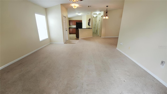 unfurnished living room with light carpet, an inviting chandelier, and lofted ceiling