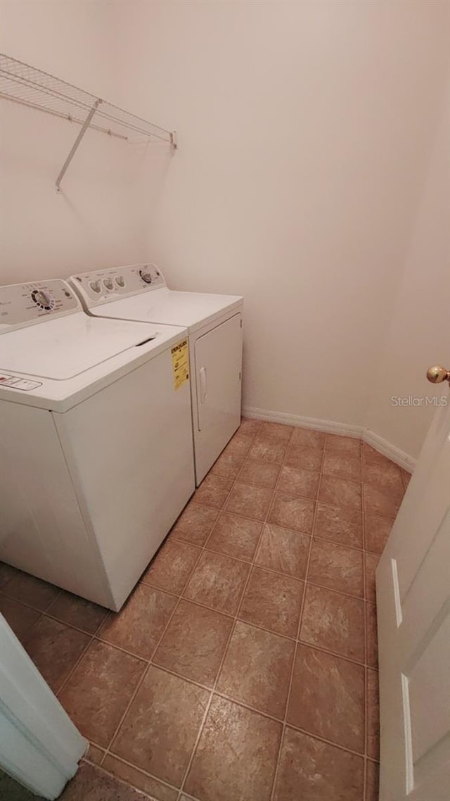 clothes washing area with washer and clothes dryer and tile patterned flooring