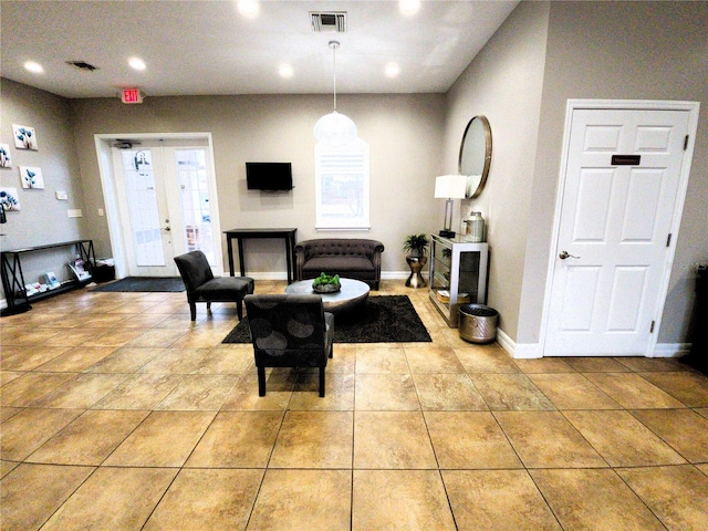 living room with light tile patterned floors, visible vents, and baseboards