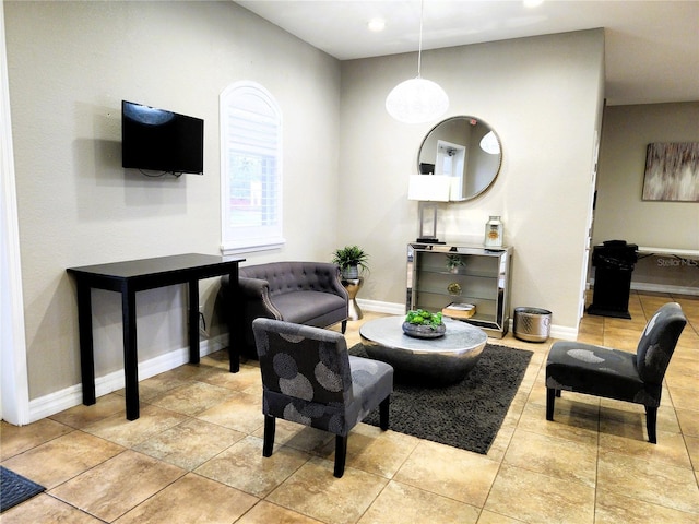 living area featuring light tile patterned flooring and baseboards