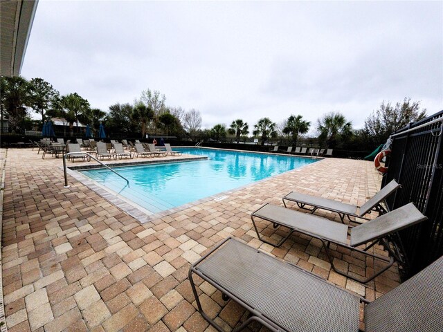 community pool featuring a patio area and fence