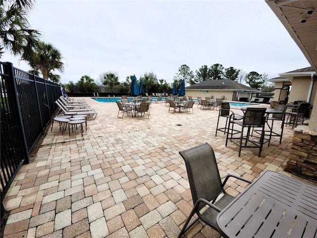 view of patio / terrace with fence and a community pool