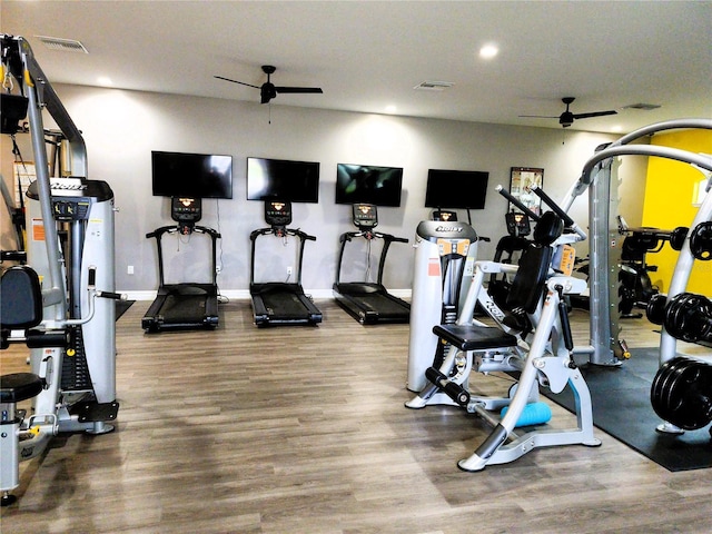 workout area featuring ceiling fan, wood finished floors, visible vents, and baseboards