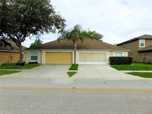 single story home with concrete driveway, an attached garage, and stucco siding