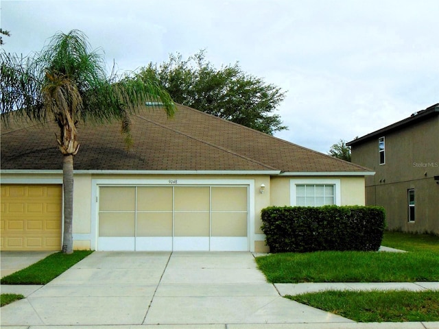 view of front of house featuring concrete driveway, roof with shingles, an attached garage, and stucco siding