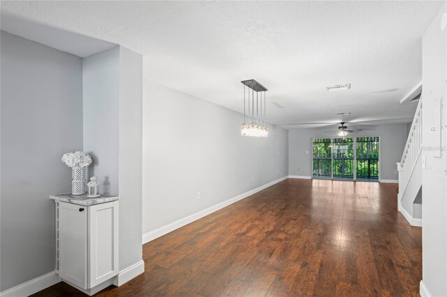 unfurnished room featuring ceiling fan, dark hardwood / wood-style flooring, and a textured ceiling