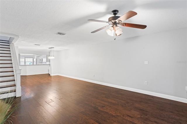 unfurnished living room with dark hardwood / wood-style floors, ceiling fan, and a textured ceiling