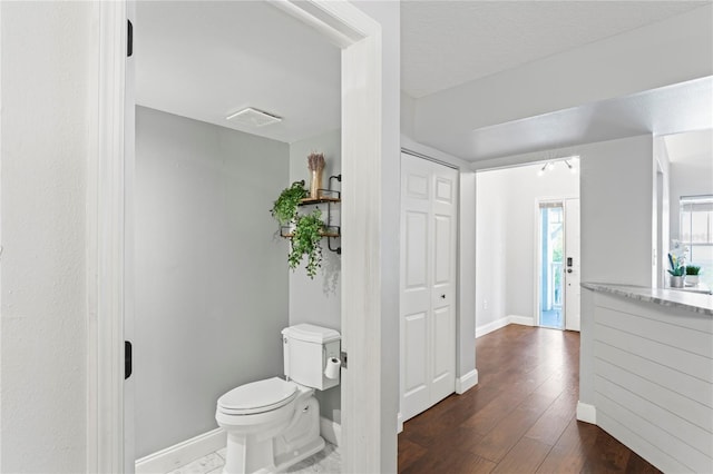 bathroom with wood-type flooring and toilet