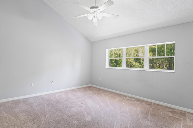 carpeted spare room featuring a textured ceiling, ceiling fan, and vaulted ceiling