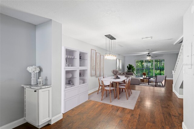 dining area featuring a textured ceiling, dark hardwood / wood-style flooring, and ceiling fan