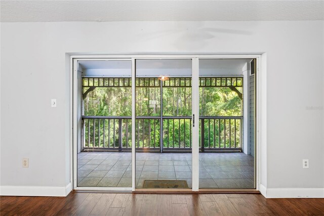 doorway featuring wood-type flooring and a textured ceiling