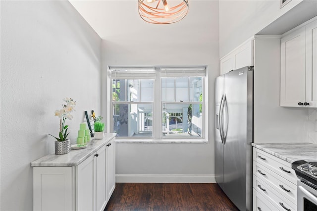 kitchen with white cabinets, dark hardwood / wood-style floors, light stone counters, and stainless steel appliances