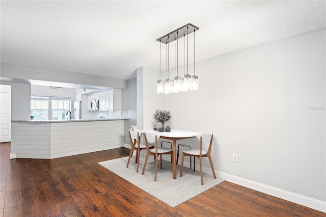 dining room featuring dark hardwood / wood-style floors and a textured ceiling