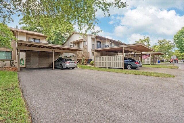 view of front of property with a carport, a front yard, and a balcony