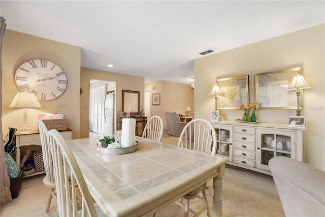 dining space featuring light carpet