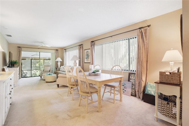 carpeted dining space featuring ceiling fan