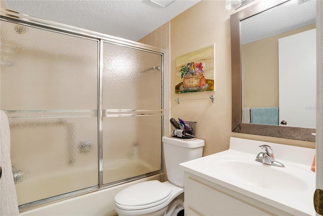 full bathroom featuring toilet, vanity, a textured ceiling, and shower / bath combination with glass door