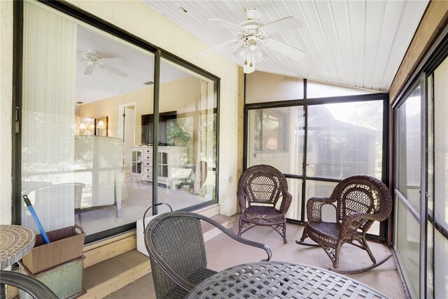 sunroom / solarium featuring vaulted ceiling, plenty of natural light, and ceiling fan