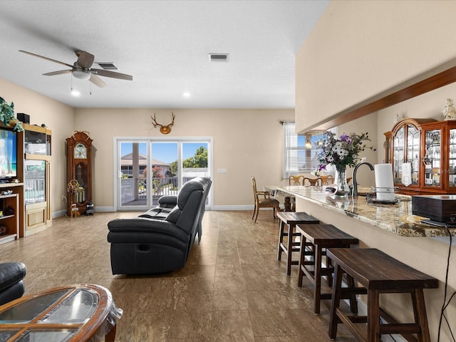 living room featuring ceiling fan and a textured ceiling