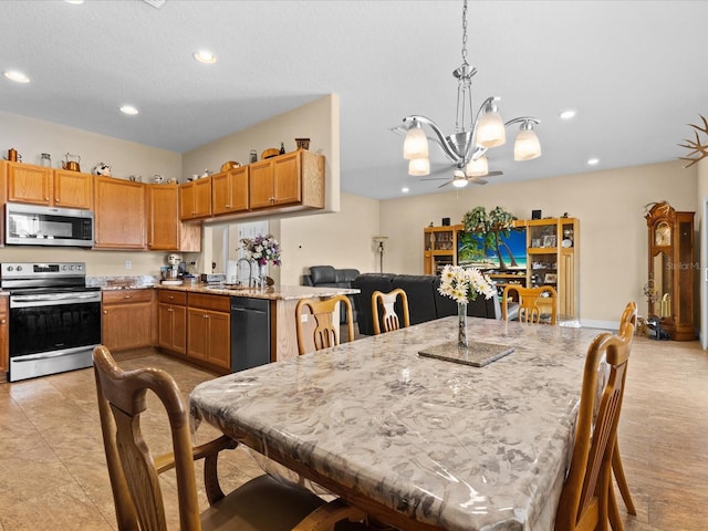 tiled dining area with ceiling fan with notable chandelier and sink