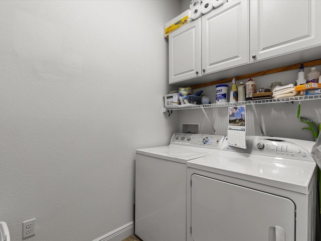 laundry room featuring cabinets and washer and clothes dryer