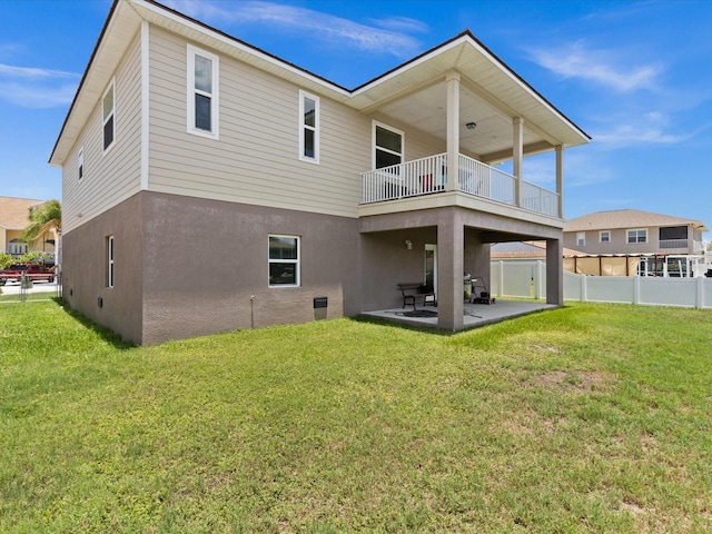 back of house with a balcony, a yard, and a patio