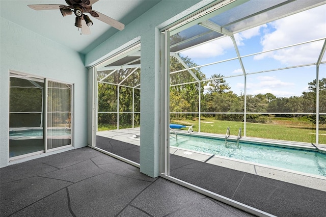 unfurnished sunroom featuring ceiling fan and a swimming pool