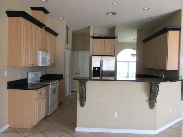 kitchen featuring light tile patterned floors, white appliances, kitchen peninsula, and light brown cabinets