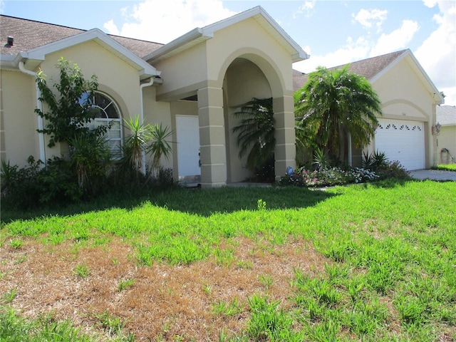 view of front of house with a garage and a front lawn