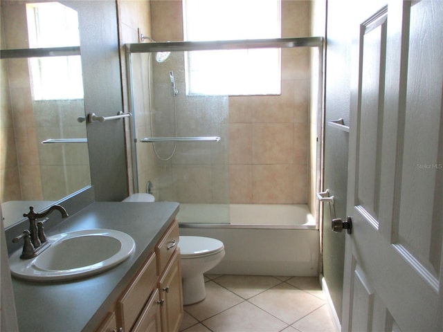 full bathroom featuring vanity, bath / shower combo with glass door, tile patterned floors, and toilet