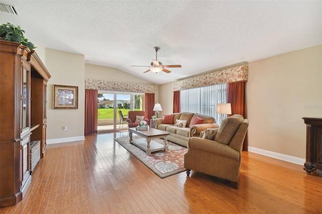 living room featuring a textured ceiling, wood-type flooring, ceiling fan, and vaulted ceiling