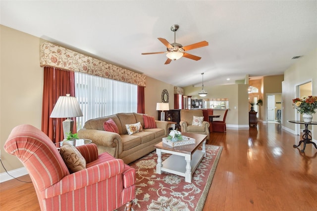 living room featuring ceiling fan, vaulted ceiling, and hardwood / wood-style flooring