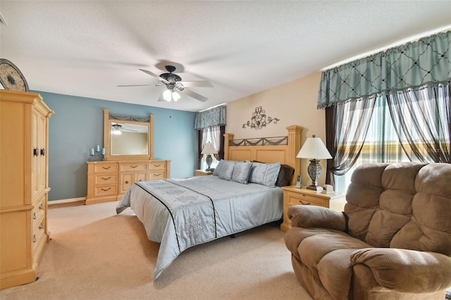 bedroom featuring light carpet, ceiling fan, and a textured ceiling