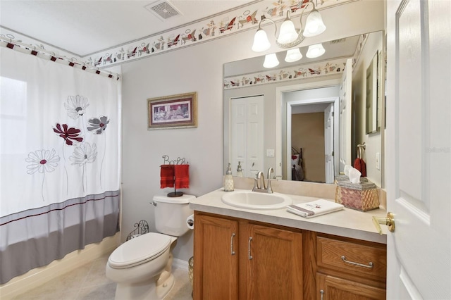 bathroom featuring tile floors, vanity, and toilet