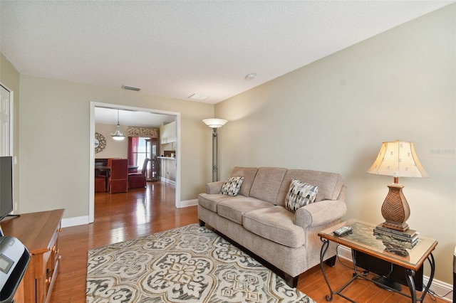 living room featuring a textured ceiling and wood-type flooring