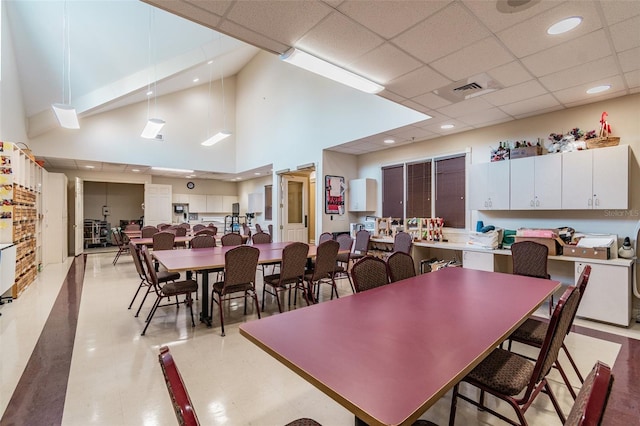 dining room featuring a high ceiling and a drop ceiling