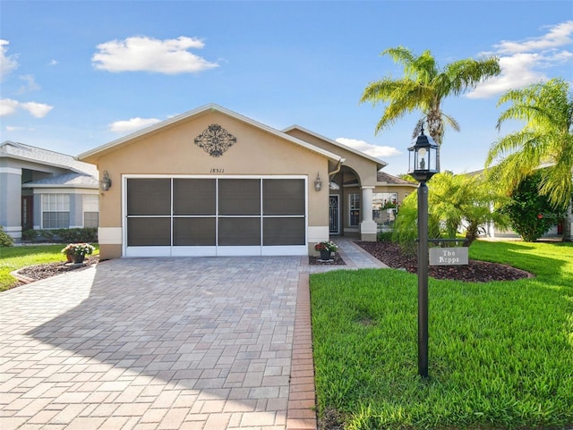 ranch-style house with a garage and a front lawn