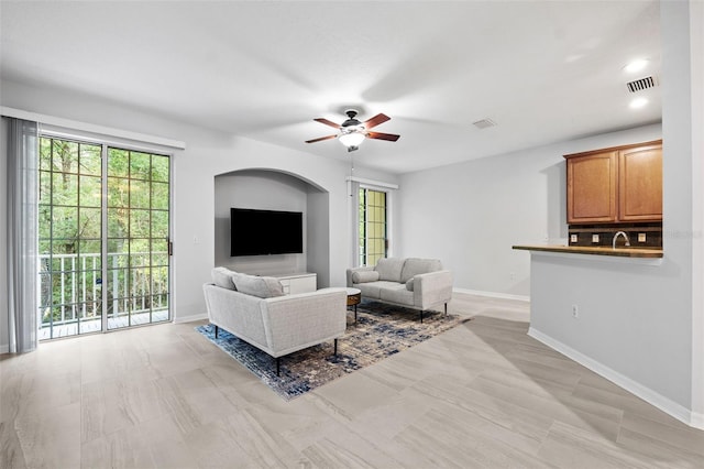 living room with ceiling fan and sink