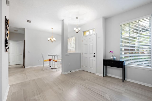 entryway with a wealth of natural light and an inviting chandelier