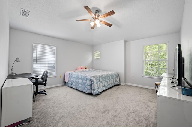 bedroom featuring ceiling fan, carpet floors, and multiple windows