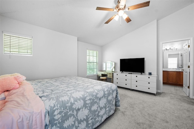 carpeted bedroom with connected bathroom, ceiling fan, and vaulted ceiling