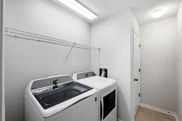 washroom featuring washer and dryer and a textured ceiling