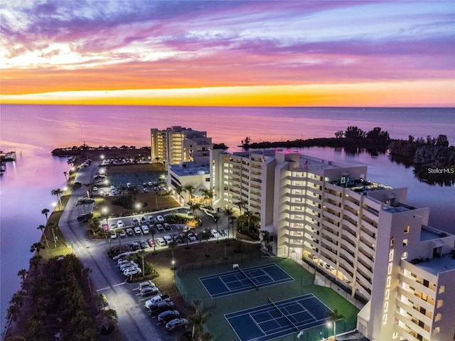 aerial view at dusk featuring a water view