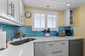 kitchen featuring white cabinets, dishwasher, and sink