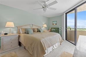 bedroom with floor to ceiling windows, access to outside, multiple windows, and ceiling fan